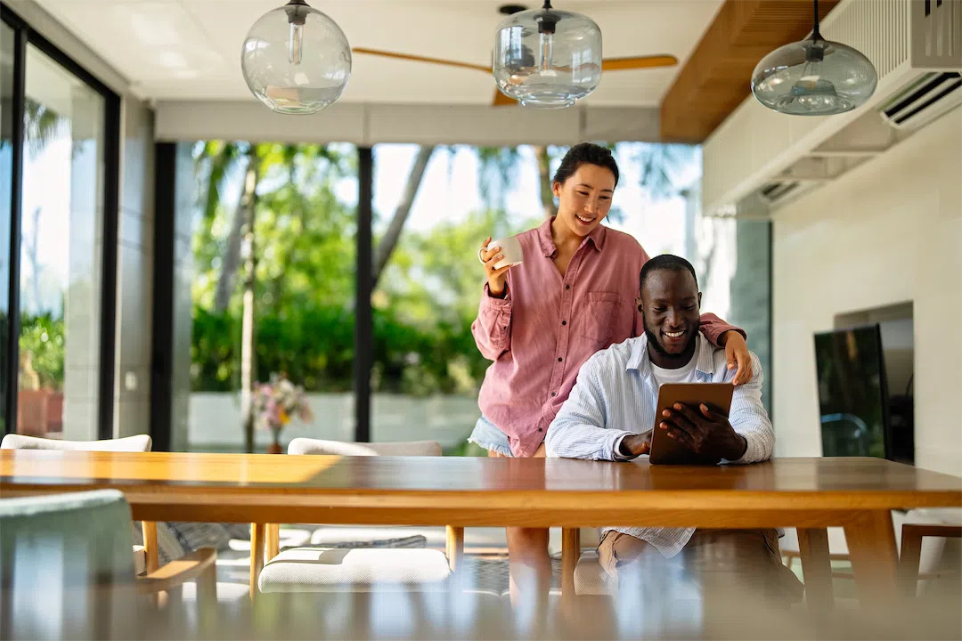A couple researches Anchorage housing market trends on their laptop.
