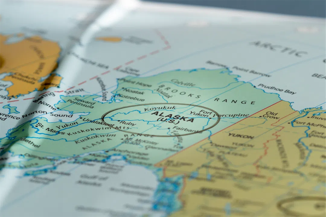 A world map with Alaska in focus, representing the Anchorage real estate market report.